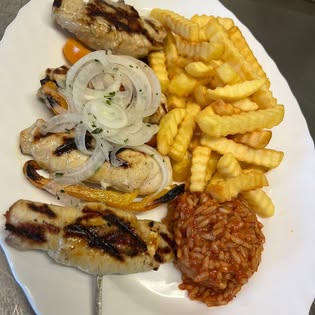 Gegrillte Fleischspieße mit Pommes und Reis bei Zorbas
